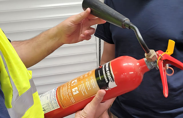 holding fire extinguisher